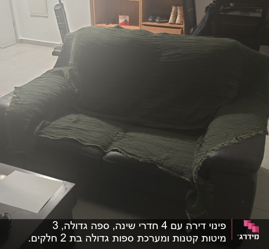 ספת עור וכוננית מדפים בסלון דירה לפני פינוי